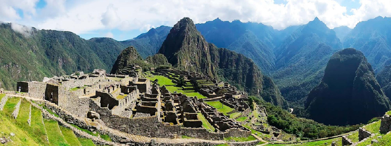 Traveler admiring sunrise over Machu Picchu ruins